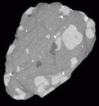 A 500 micron slice through diamondiferous eclogite, 50 mm in diameter from Udachnaya,Yakutia. Matrix is partially altered clinopyroxenes; large, light porphyroblasts are garnet; and dark crystals at center and on left are diamonds. (Sample provided by Dr. Larry Taylor, University of Tennessee at Knoxville).
