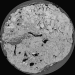 1 mm thick CT slice of a drained saprolite core encased in PVC (248 mm in diameter). The scan clearly shows fractures, macroporosity including root holes, and weathering patterns that define areas of differing competency and modes of permeability. By gathering closely-spaced contiguous slices, it is possible to measure the 3D extent of each fracture in great detail. (Sample courtesy of Dr. Geri Moline, Oak Ridge National Laboratory).