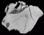 Single scan of a meteorite impact glass, showing a compact clast inclusion of higher and lower density material. Folded structure of glass is visible both defined by subtle density differences in the matrix as well as by the alignment of the vesicles. Dark line in upper right is a fracture. Sample is approximately 4.5 cm in diameter. (Sample courtesy of Dr. Christian Koeberl, University of Vienna).